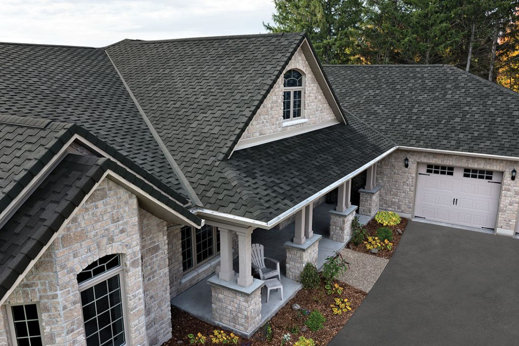 Gray modern farmhouse style house with black metal roof and white trim.