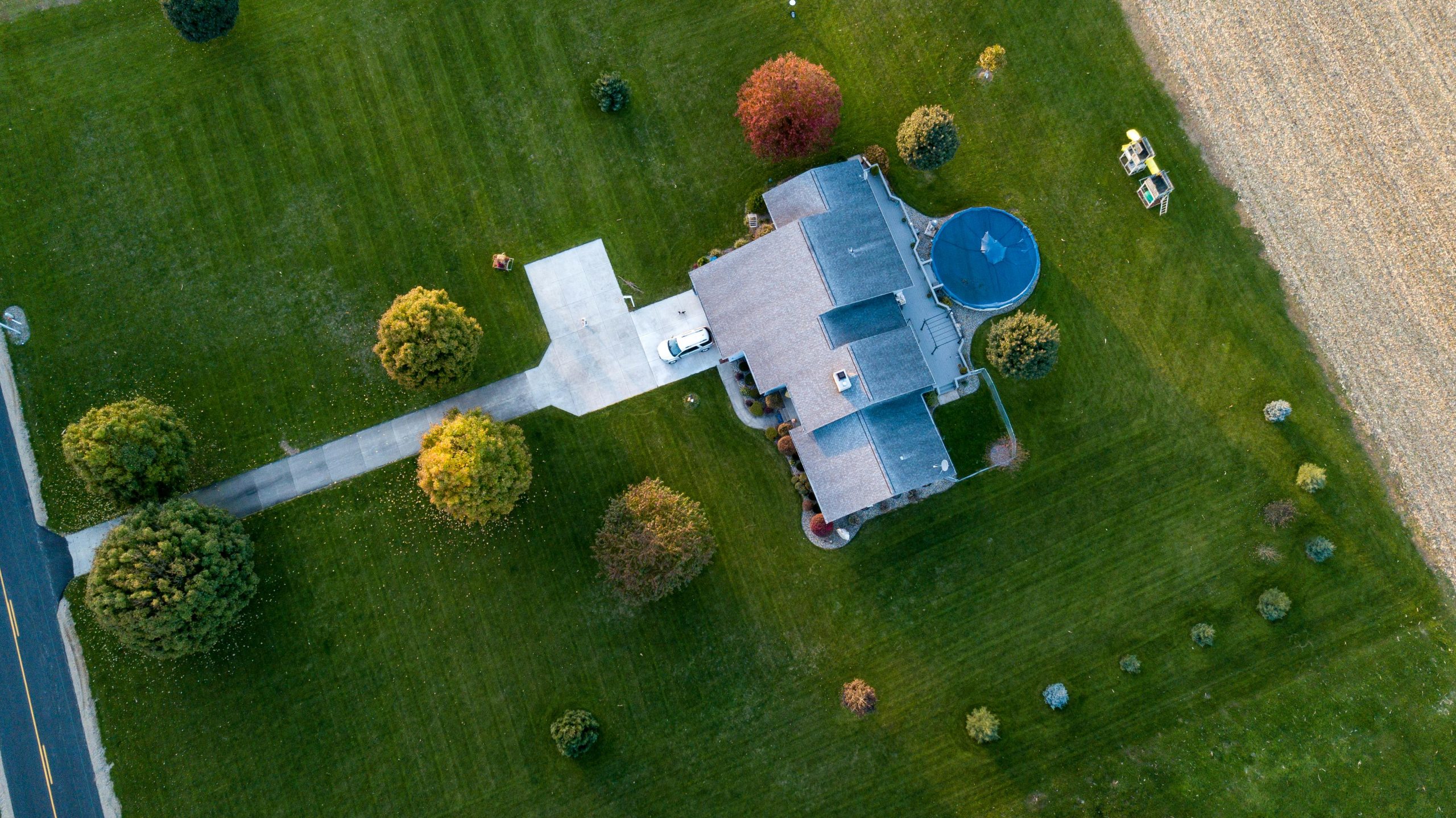 Aerial view of a house with a large green lawn.